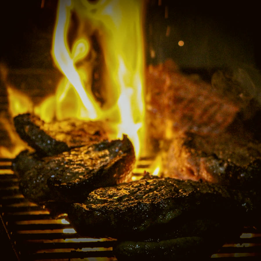 Steaks searing over an open live-oak flame
